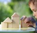 boy raises his hand to the house from wooden cubes/DollarPhotoClub